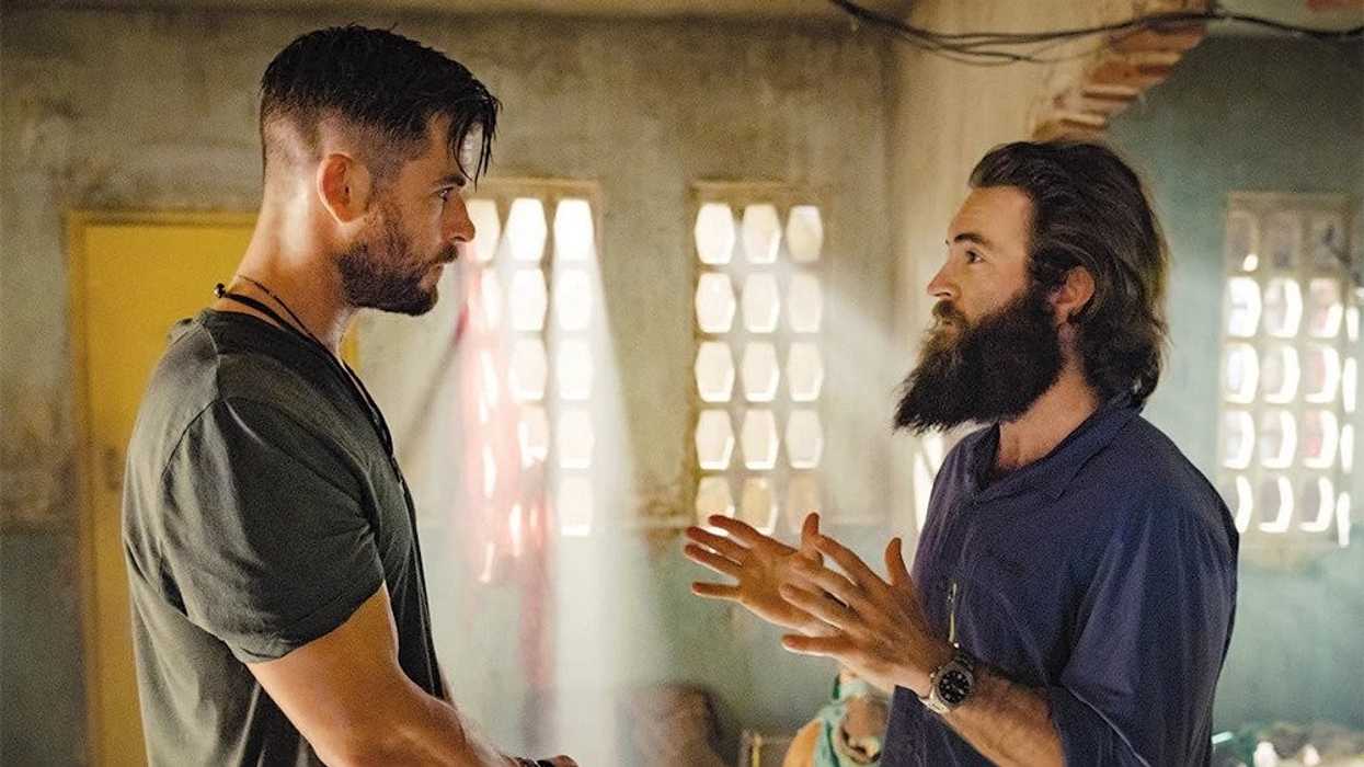 Two men talking on a set, 'Extraction 2'