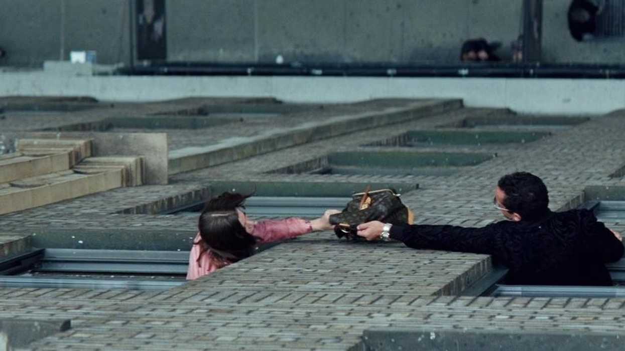 Two people exchanging a bag through windows in 'Uncut Gems'