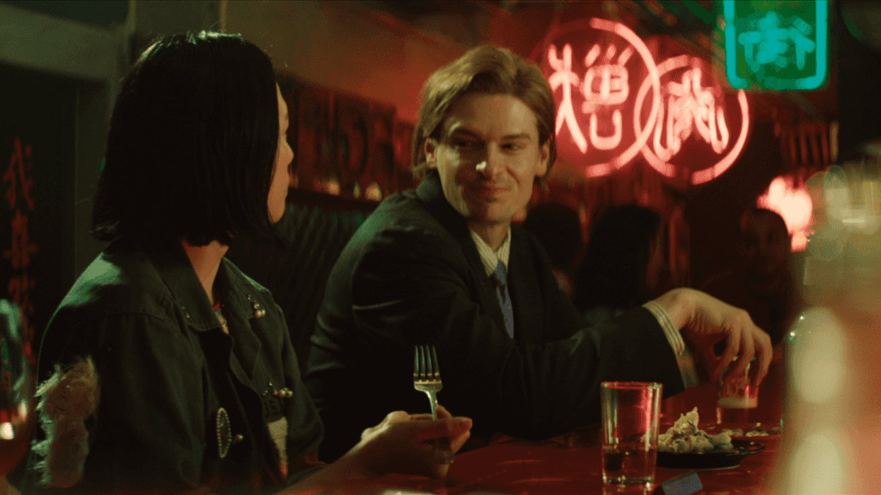 Two people talking and drinking at a bar