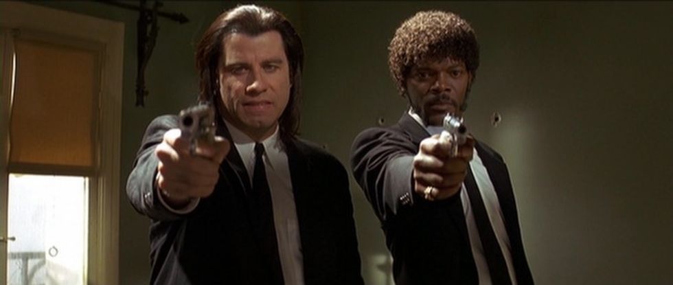 Two shot of John Travolta as Vincent Vega and Samuel L. Jackson as Jules Winnfield pointing guns in 'Pulp Fiction'