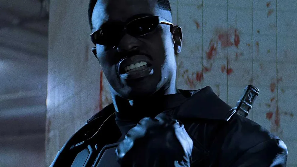 Wesley Snipes as Blade pumping his fist in front of a bloody tile wall in Blade