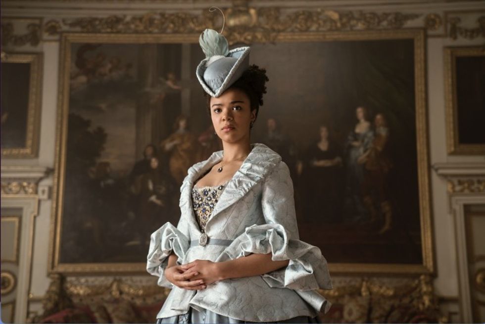 Young Queen Charlotte, played by India Amarteifio, in front of a painting in 'Queen Charlotte: A Bridgerton Story'
